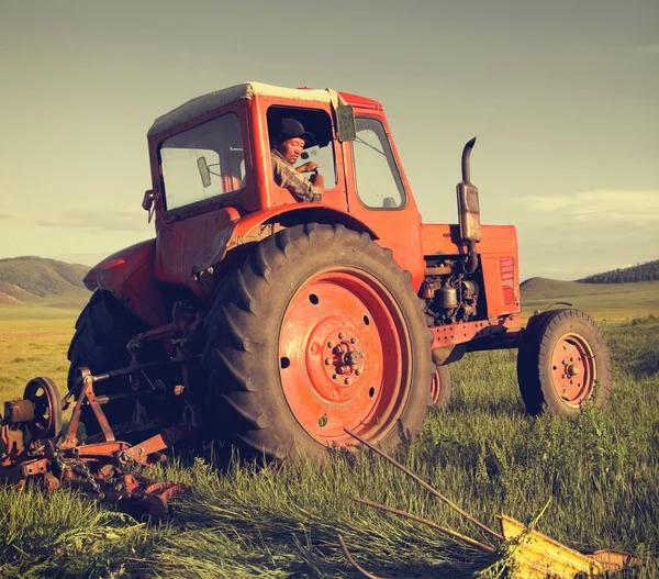 Mongolian farmer driving tractor — Stock Photo, Image