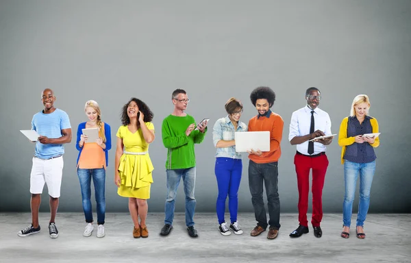 Persone in piedi insieme con dispositivi digitali — Foto Stock