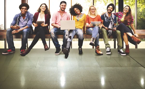 Amigos sentados en el banco con computadoras portátiles — Foto de Stock