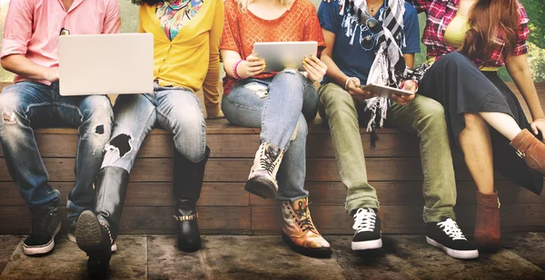 Friends sitting on bench with laptop computers — Stock Photo, Image