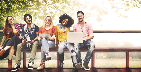 друзья сидят на скамейке с ноутбуками
