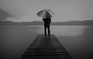 Man Holding an Umbrella at Lake Concept clipart