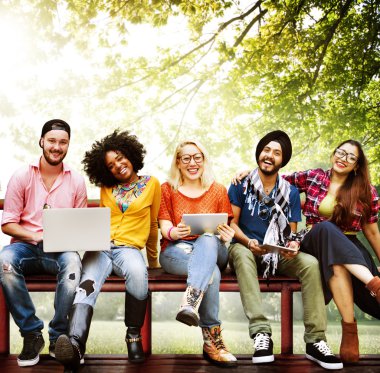 mutlu arkadaş dizüstü bilgisayar ile bankta oturmuş