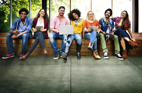 Freunde sitzen mit Laptop auf Bank — Stockfoto