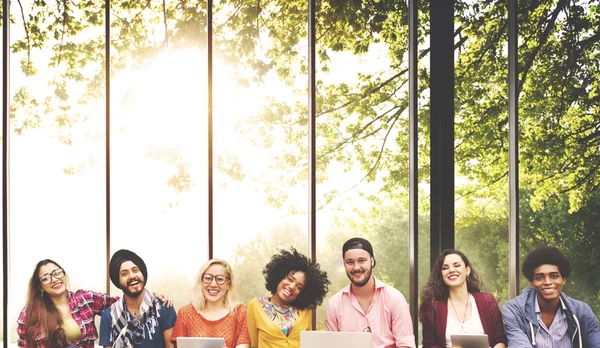 Amigos felizes sentados no banco com laptop — Fotografia de Stock