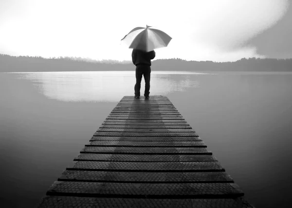 Man innehar ett paraply på sjön Concept — Stockfoto