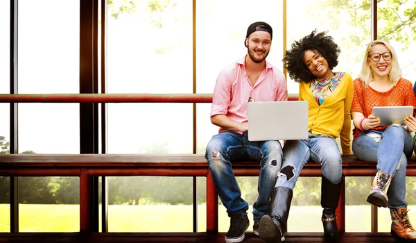 Amigos sentados en el banco con computadoras portátiles — Foto de Stock