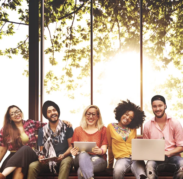 Amigos sentados en el banco con computadoras portátiles — Foto de Stock