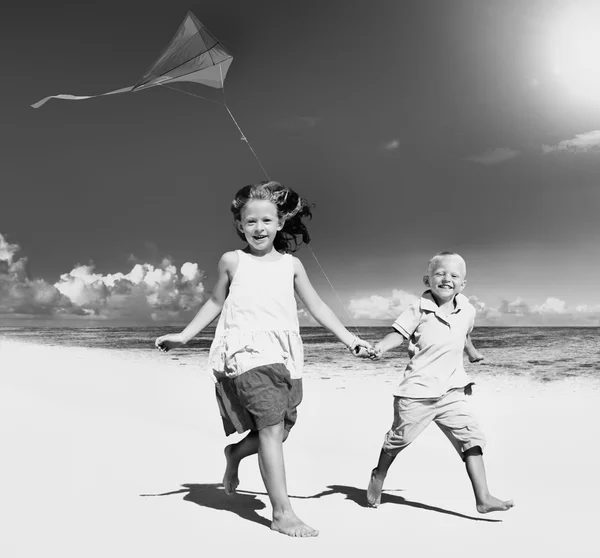 Broer/zus spelen samen op het strand Concept — Stockfoto