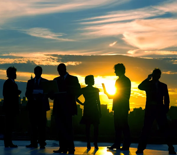 İş insanlar siluetleri günbatımı üzerinde — Stok fotoğraf