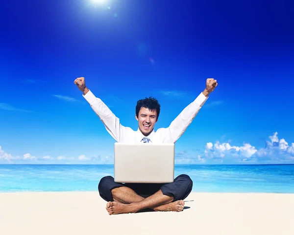 Деловой человек на пляже с ноутбуком — стоковое фото