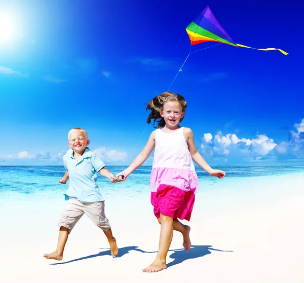 Broer/zus spelen samen op het strand Concept — Stockfoto