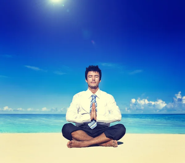 Бизнесмен медитирует на пляже Концепция — стоковое фото