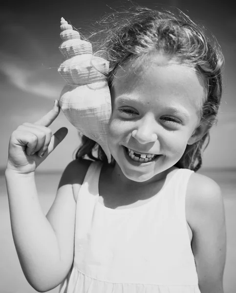 Chica con concha marina en la costa Concepto — Foto de Stock