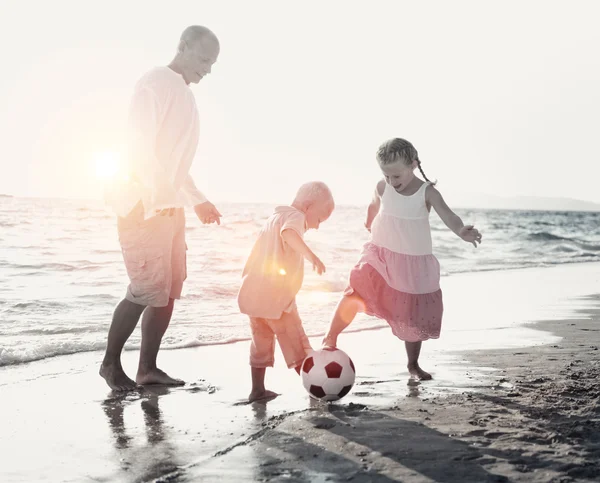 Familie am Strand spielt Fußballkonzept — Stockfoto