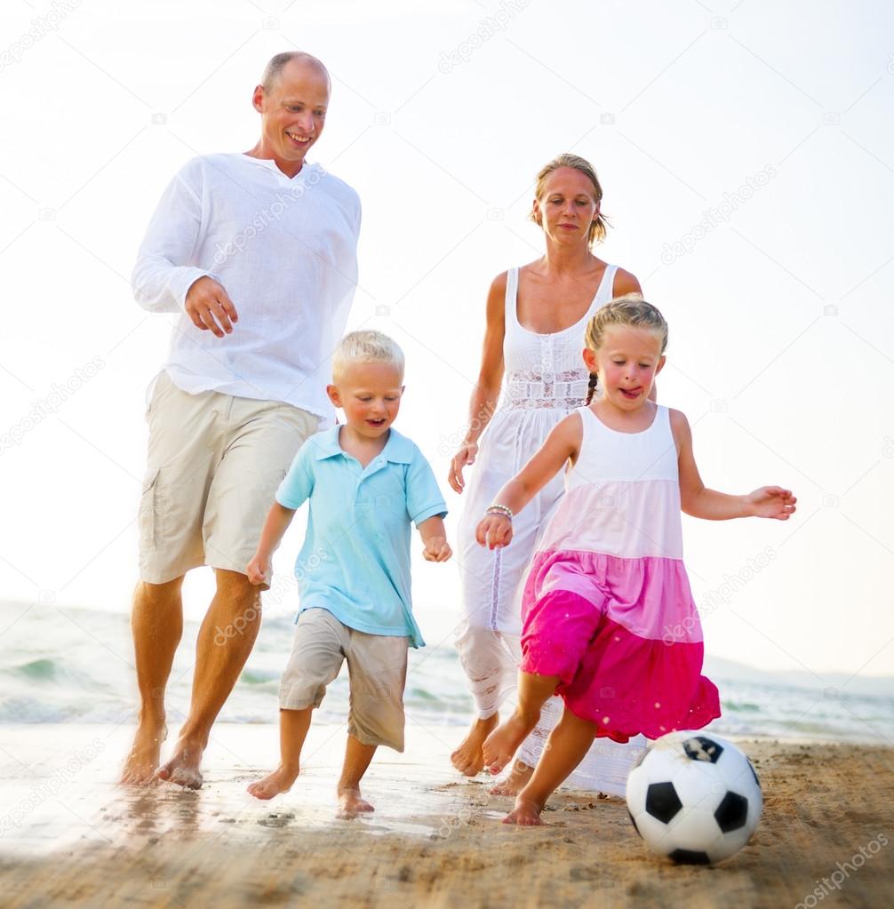 Family at Beach playing Football Concept