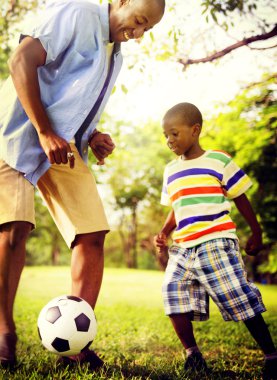 Baba oğul futbol oynuyor.