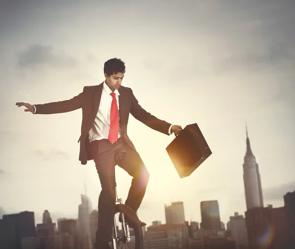 Businessman riding one wheel bicycle — Stock Photo, Image