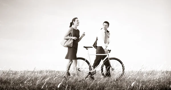 Деловая пара с велосипедом — стоковое фото