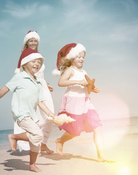 Family at beach in santa hats — Stock Photo, Image