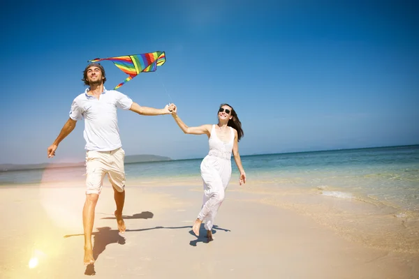 Casal brincando com pipa, relaxando no conceito de praia — Fotografia de Stock