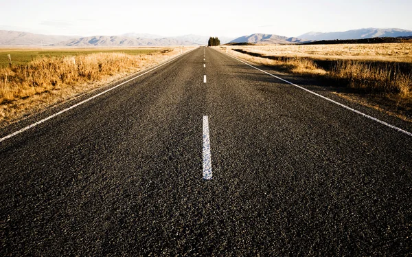 Carretera lleva montañas — Foto de Stock