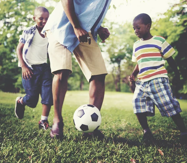 Pai e filhos jogando futebol — Fotografia de Stock