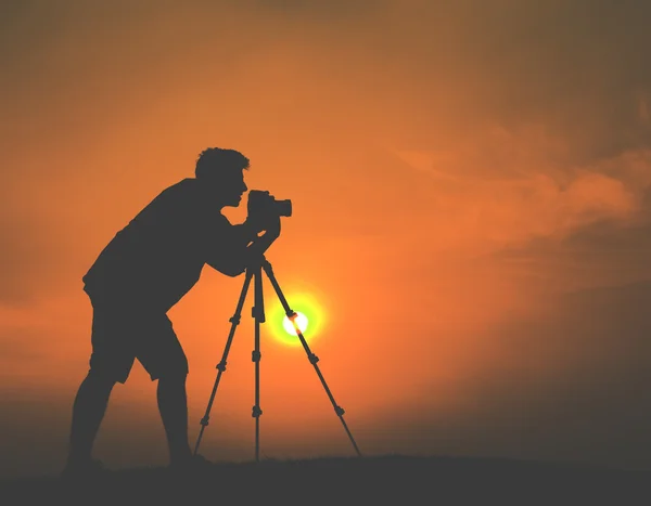 Jeune photographe tournage coucher de soleil — Photo