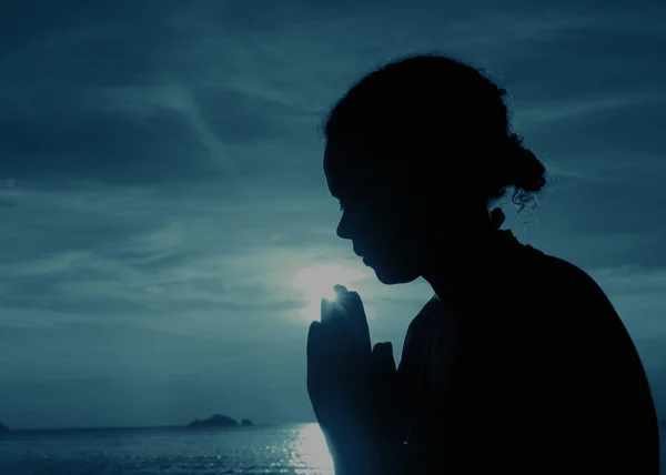 Genç kadın günbatımında dua — Stok fotoğraf