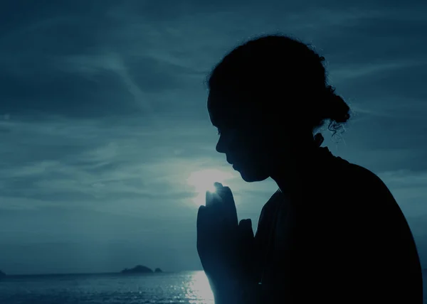 Young woman praying at sunset — Stock Photo, Image