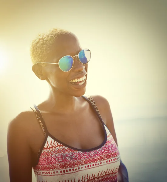 Frau mit Sonnenbrille lächelt am Strand — Stockfoto