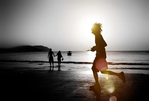 Człowiek jogging na plaży o zachodzie słońca — Zdjęcie stockowe