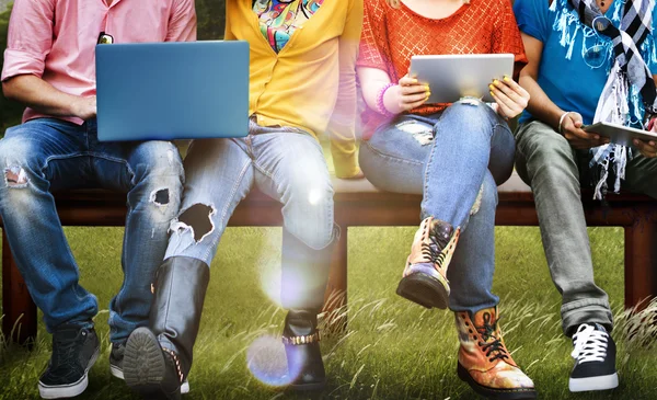 Freunde sitzen mit Laptop auf Bank — Stockfoto