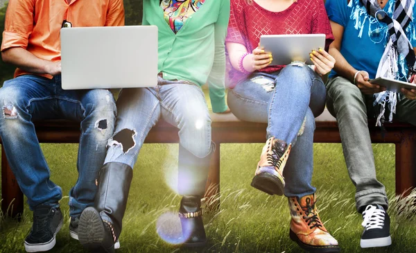 Amigos sentados en el banco con computadoras portátiles — Foto de Stock