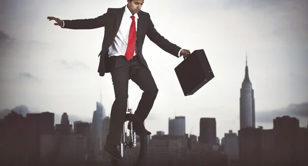 businessman riding one wheel bicycle