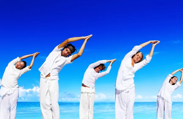 Люди роблять йога на пляжі концепції — стокове фото