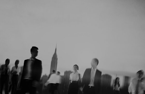 темные силуэты гуляющих деловых людей
