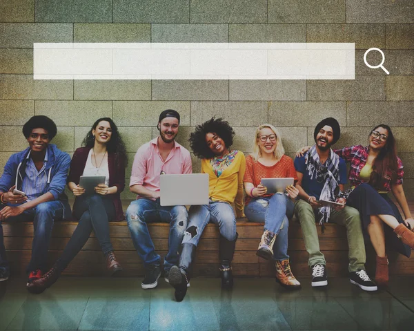 Friends sitting on bench with wireless devices — Stock Photo, Image