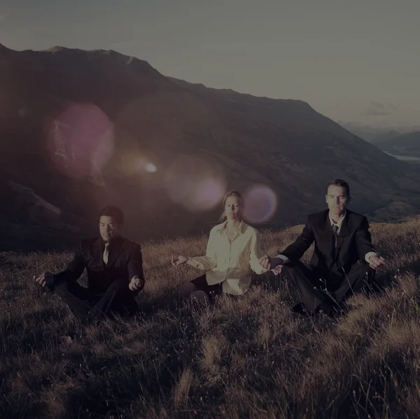 Деловые люди медитируют на горах — стоковое фото
