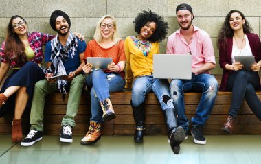 mutlu arkadaş dizüstü bilgisayar ile bankta oturmuş