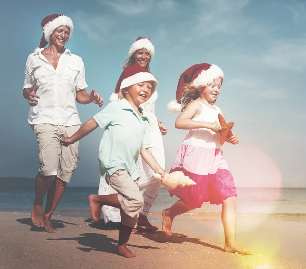 Family at beach in santa hats — Stock Photo, Image