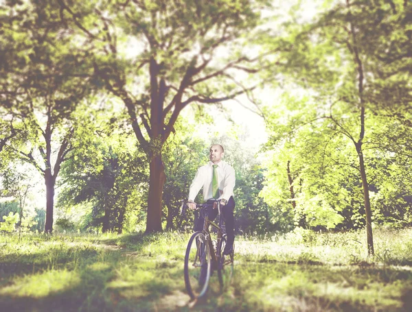 Businessman on bicycle in forest — Stock Photo, Image