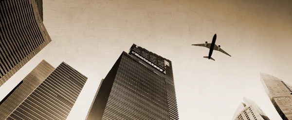 Airplane flying over city buildings — Stock Photo, Image