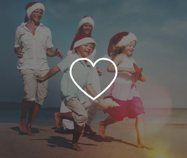 Family at beach in santa hats — Stock Photo, Image