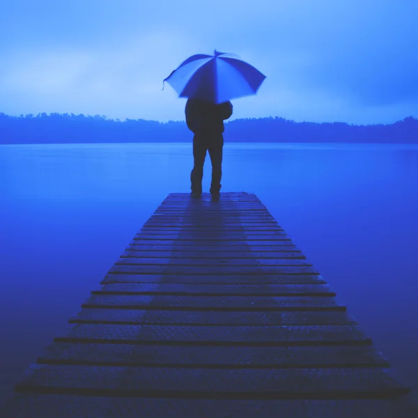Mann mit Regenschirm am See — Stockfoto