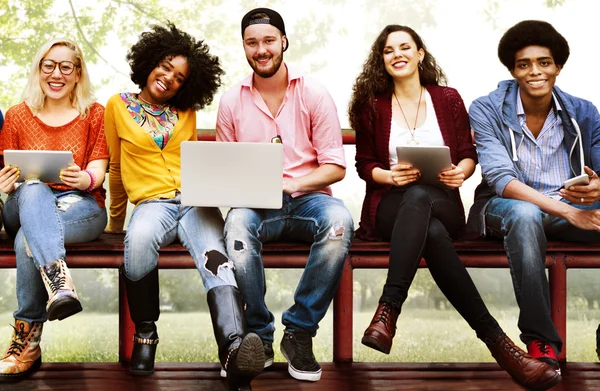 Amigos en el banco con el ordenador portátil y la tableta PC — Foto de Stock