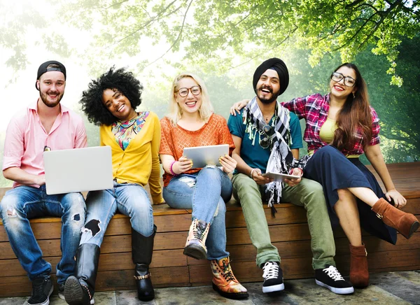 Amigos no banco com laptop e tablet pc — Fotografia de Stock