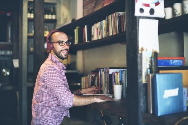 kulaklık dizüstü bilgisayar üzerinde çalışan adamla