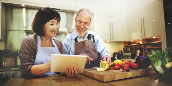 Cocina en pareja y el uso de tabletas digitales — Foto de Stock