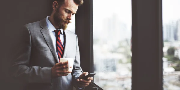 Businessman with coffee using smartphone — Stock Photo, Image